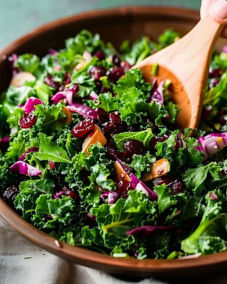 Chopped kale salad with cranberries, nuts, and vinaigrette on a plate