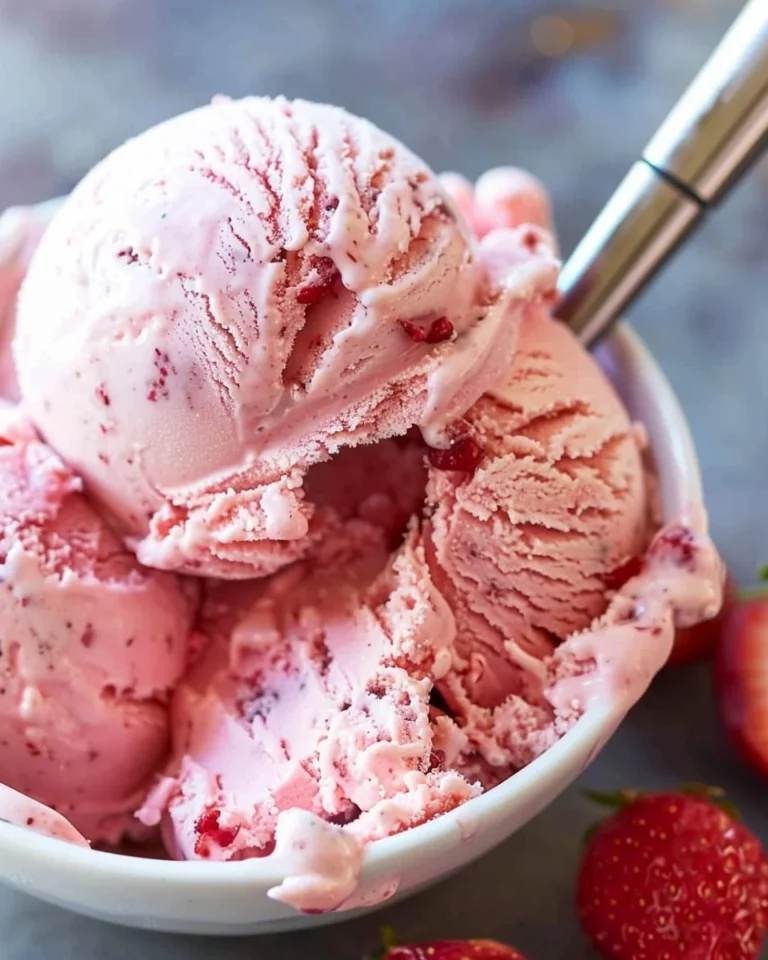 Delicious homemade strawberry ice cream in a bowl with fresh strawberries