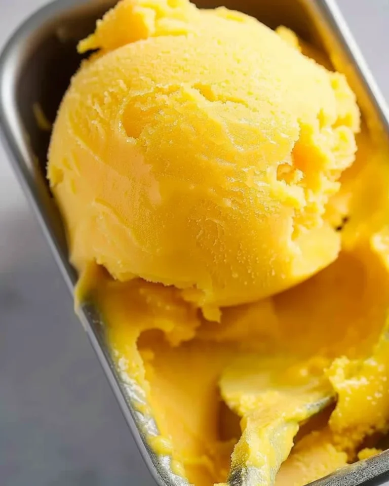 Delicious homemade mango sorbet in a bowl topped with mint leaves
