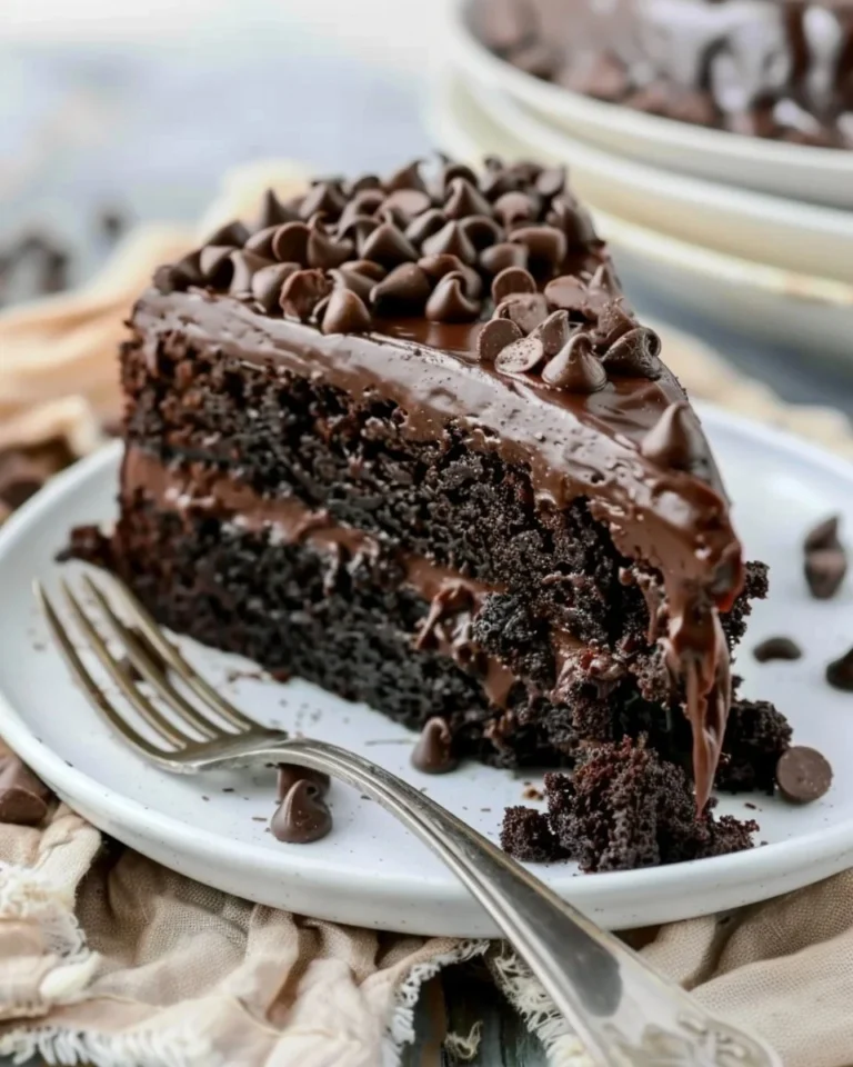 Delicious chocolate zucchini cake topped with chocolate frosting and grated zucchini.